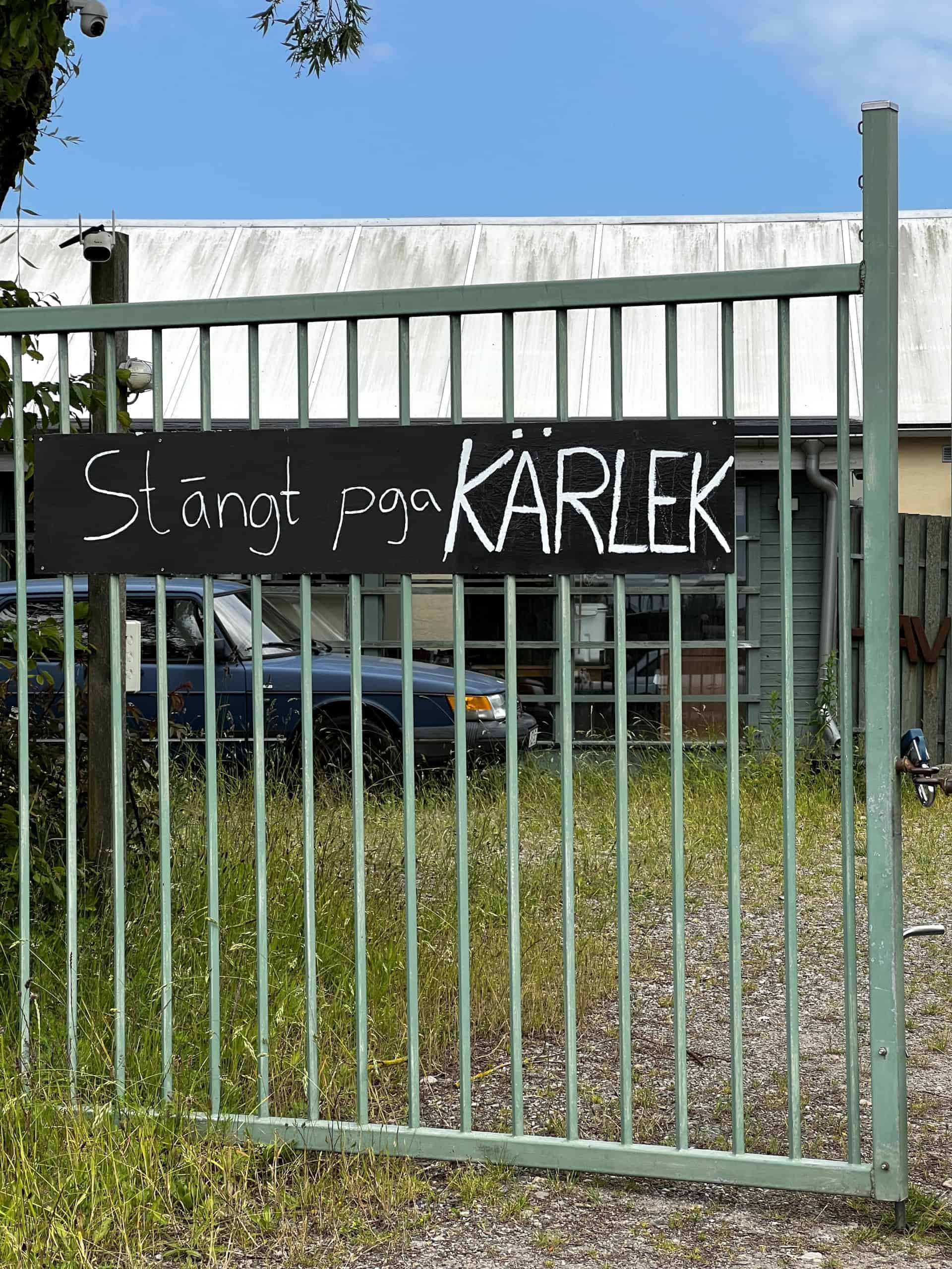 En grøn port med et håndskrevet skilt: Stängt pga kärlek