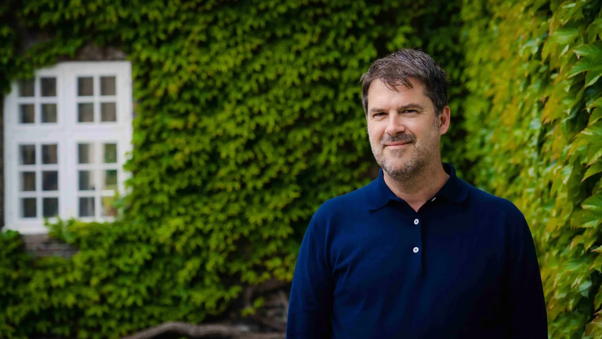 Eskil Holten foran en grøn vedbendvæg